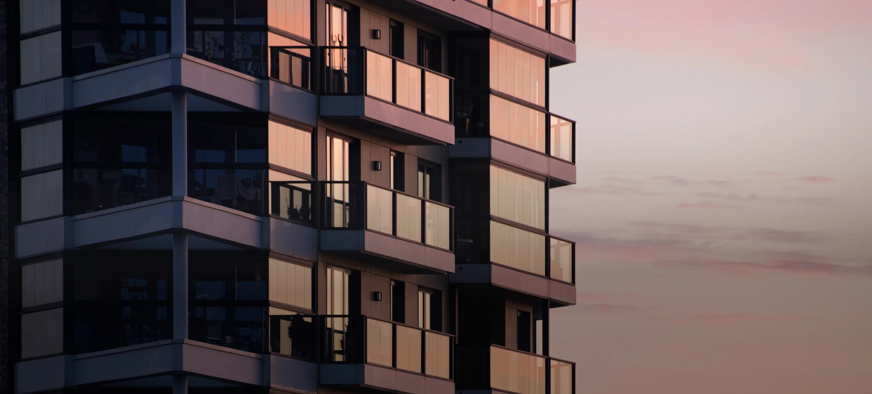 Modern multi-storey building with balconies at dusk