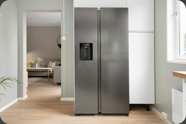 A kitchen with a refrigerator standing against the far wall