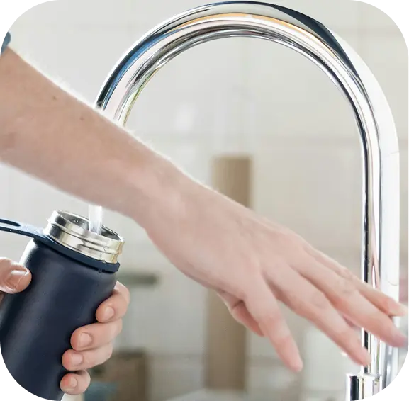 Filling a bottle at a kitchen tap